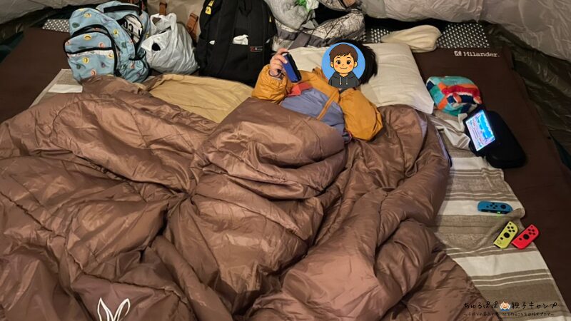 わが家の長男がDODわがやのシュラフで横になっている