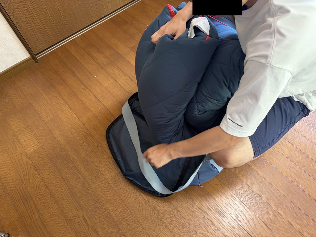コールマン マルチレイヤースリーピングバッグを収納袋に入れている様子
