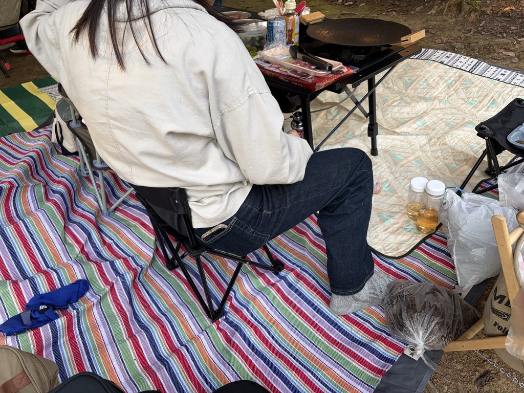 大人がダイソーのアウトドアチェアに座っている様子