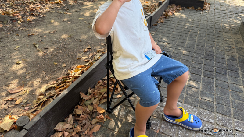 4歳の子どもがダイソーのアウトドアチェアに座っている様子