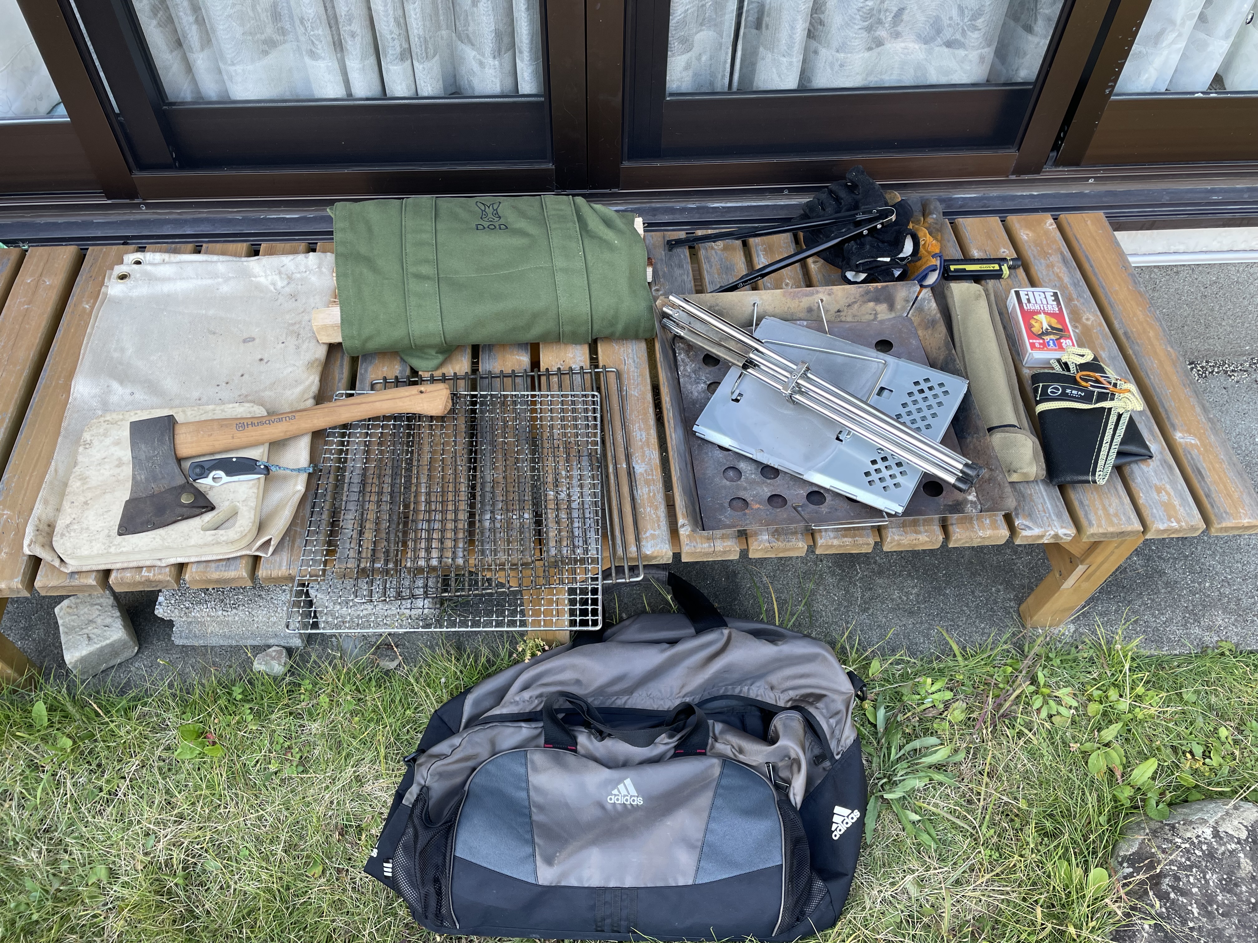 旅行用バッグの中に収納したBBQ用品や焚き火グッズを一覧で紹介した写真