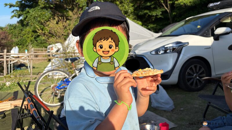 キャンプで焼いたピザを食べる次男