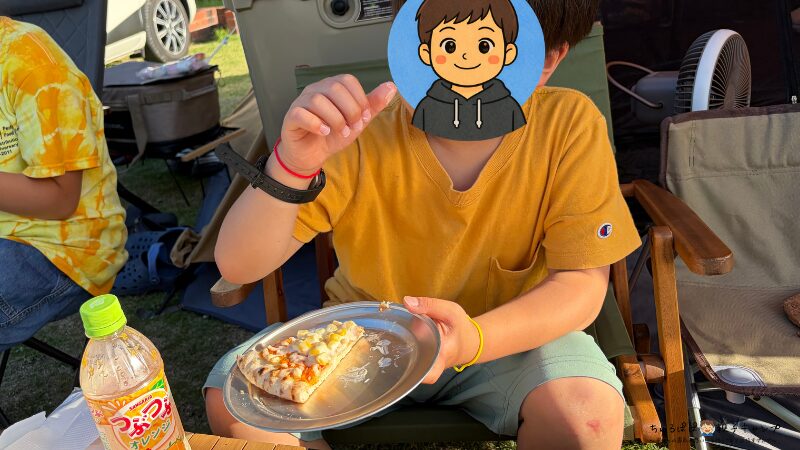 キャンプで焼いたピザを食べる長男