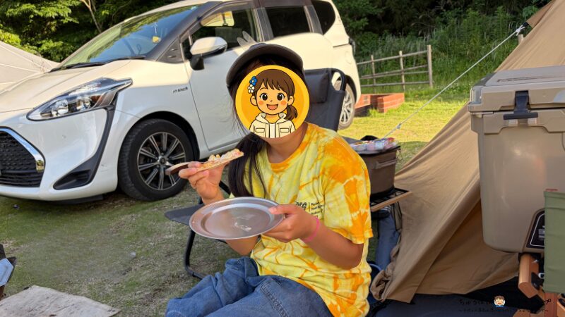 キャンプで焼いたピザを食べる長女
