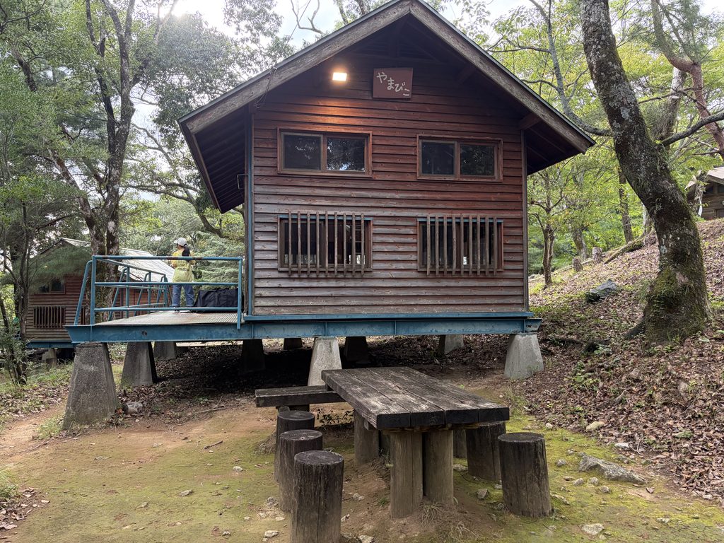 野岳湖キャンプ場のバンガローの庭にある木製テーブルといす、外灯