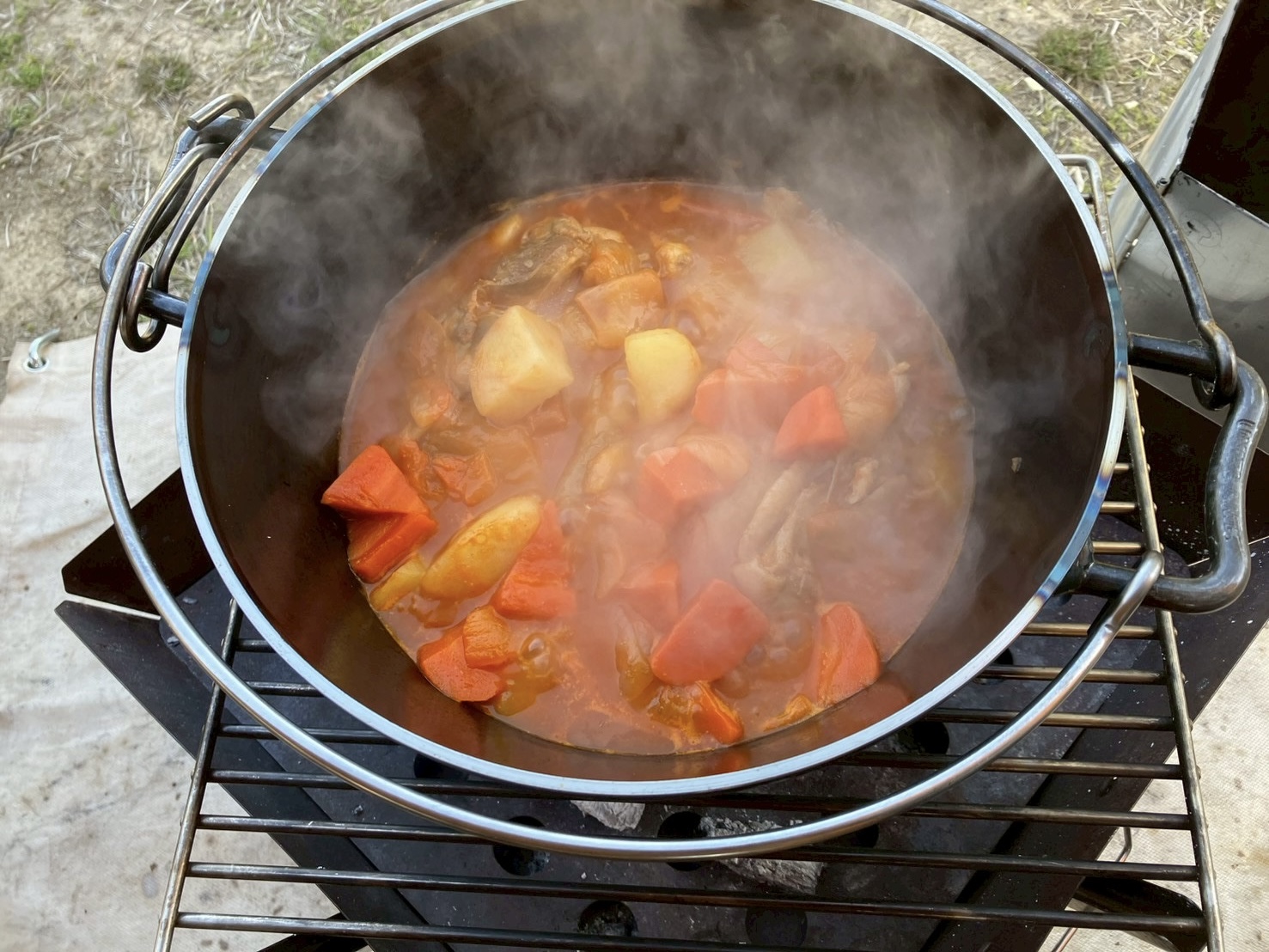 ユニフレーム ファイアグリルでUFダッチオーブンを使ってトマト煮込みを作るキャンプ料理の様子