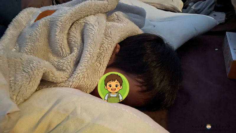 冬キャンプで寝袋に入って寝ている次男